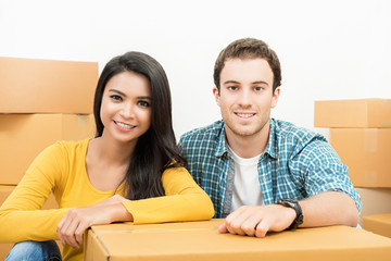 Smiling happy interracial couple just moving into new house