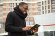 © A Stock Studio - Happy man with a digital tablet in his hands. Portrait of a smiling afro american with glasses.