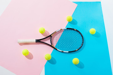 Wall Mural - top view of tennis racket and balls on blue and pink papers