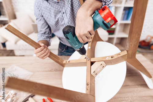 The Man Handyman Is Engaged In Assembling The Chair The