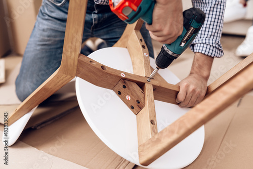 Fotografía The man handyman is engaged in assembling the chair