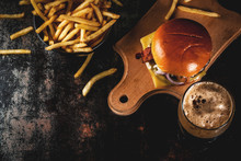 Fresh Meat And Cheese Burger With French Fries And Glass Of Dark Ginger Beer, On Dark Blue Background, Copy Space Top View