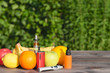 Electronic cigarette. Liquid and fruits on a wooden table. Place for text.