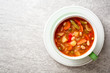 Italian minestrone soup in bowl on gray stone background