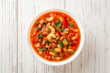 Wall Mural - Italian minestrone soup on white wooden background.