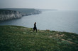 © SHOTPRIME STUDIO - Beautiful young woman standing on a cliff of a mountain near the sea