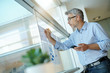 © goodluz - Businessman talking on phone while anaylzing results on charts
