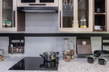 Comfortable And Functional Kitchen In Hi-Tech Style. The Electric Stove Is Built In The Marble Countertop. Apron Made Of Ceramic Mosaic Tiles In Gray.