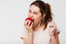 Close Up Portrait Of A Hungry Pretty Girl Biting An Apple