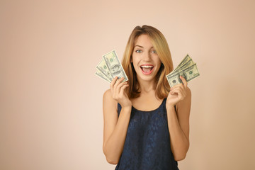 Poster - Happy young woman with dollar banknotes on color background