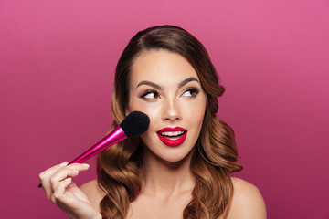 pretty caucasian lady with make up brush looking aside