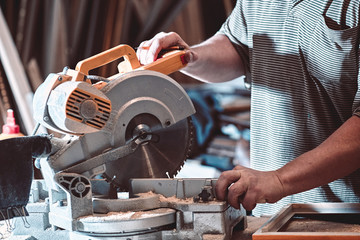 The joiner processes the billet on a circular saw.