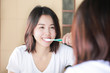 © jayzynism - Young woman brushing her teeth at mirror. After awakening