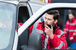 © LIGHTFIELD STUDIOS - young handsome male paramedic standing near ambulance and talking by portable radio