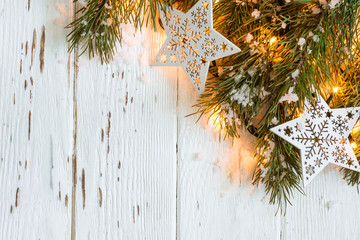 Wall Mural - Christmas snowy background. Fir branches with burning garland