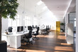 © Westend61 - Desks with PCs in bright and modern open space office