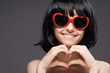 © SHOTPRIME STUDIO - Young beautiful woman on black background in sunglasses shows hands on heart