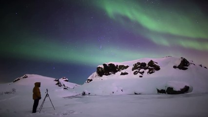 Wall Mural - photographer shooting aurora borealis over snowy volcanic terrain reykjavik iceland.mov