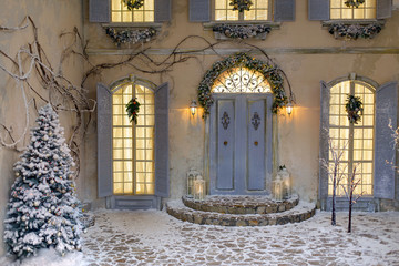 House decorated for Christmas outside, courtyard. Vintage street interior with tree, door and lights in windows. Winter christmas background.