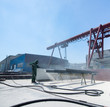 factory for cleaning of metal by sandblasting. the worker performing the cleaning by sandblasting of metal structures