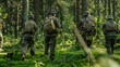 © Gorodenkoff - Squad of Five Fully Equipped Soldiers in Camouflage on a Reconnaissance Military Mission, Rifles in Firing Position. They're Moving in Formation Through Dense Forest. Back View Shot.