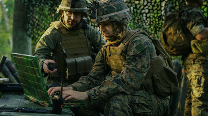 Military Staging Base, Officer Gives Orders to Chief Engineer, They Use Radio and Army Grade Laptop. They're in Camouflaged Tent in a Forest. They're on Reconnaissance Operation/ Mission.