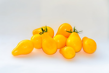 Yellow cherry tomato fruits, plant Solanum lycopersicum, white background, close up