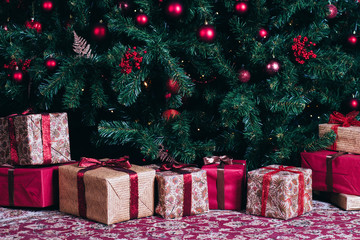 Decorated Cristmas tree with red and golden presents under it