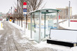 Deserted Bus Stop with a Glass Shelter in Calgary, Canada, on a Snowy Winter Day