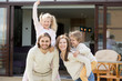 Happy family with two kids having fun together on terrace of modern own new house, smiling parents with little children spending leisure time outside beautiful home looking at camera, mortgage loan