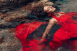 © zolotareva_elina - beautiful young woman in red dress laying dowm in water