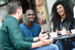 © javiindy - Multiracial group of three friends having a coffee together.