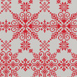 Knitted seamless pattern of white snowflakes on a red background