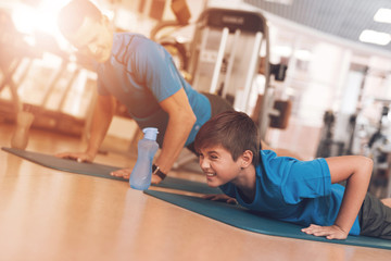 Wall Mural - Dad and son in the same clothes in gym. Father and son lead a healthy lifestyle.