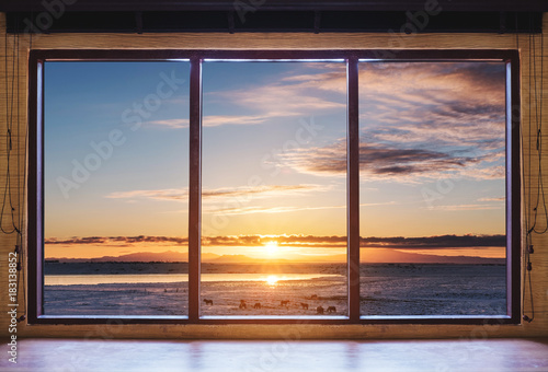 Fotografía Looking through window in the morning sunrise, wooden window frame with desk