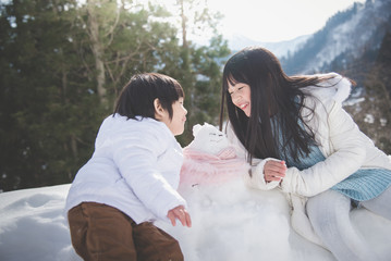 Canvas Print -  Asian children playing with snowman