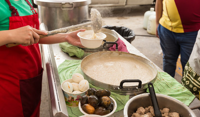 Woman use ladle to putting Pork Congee in cup.