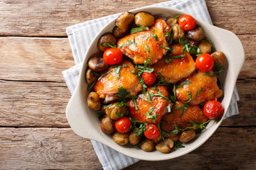 Canvas Print - Pieces of chicken fried with chestnuts and tomatoes close-up in a bowl. Horizontal top view