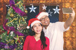 Happy couple is taking photo with Christmas tree