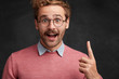 © WHstudio Leushin N - Excited bearded male nerd looks with amazed expression, gets brilliant idea, raises fore finger, going to present something to groupmates or colleagues. Handsome young man gestures in studio alone