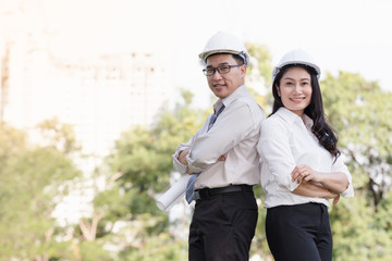 Wall Mural - asian men and women engineers work on plans construction  in the park