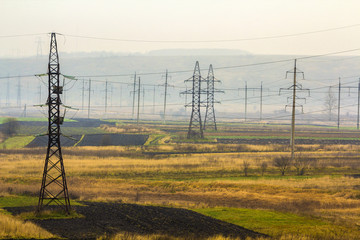 Electricity transmission power lines in foggy weather. High voltage towers