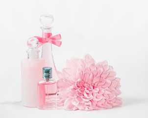 Wall Mural - pastel pink cosmetic mock up bottles product setting with flower on white background, front view. la