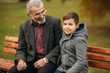 © Aleksandr - Grandpa and his grandson spend time together in the park. They are sitting on the bench. Walking in the park and rejoicing