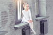 © uv_group - Little cute child girl in white dance form sitting on window at modern dance studio