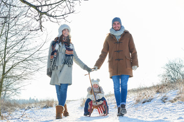 Wall Mural - Familie beim Winter Spaziergang im Schnee