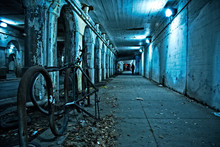 Gritty Dark Chicago City Street Under Industrial Train Bridge Viaduct Tunnel With Bicycle And Person At Night.