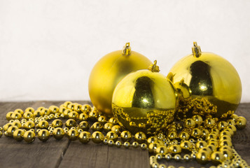 Christmas decoration with golden beads and golden shiny balls on a wooden base