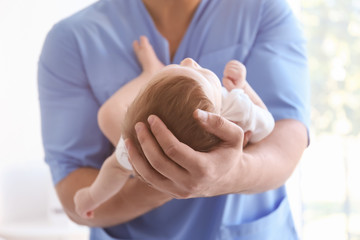 Sticker - Male doctor holding baby at hospital