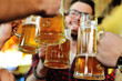 © Evgeniy Kalinovskiy - Friends clink glasses of beer glasses close-up on the background of the pub